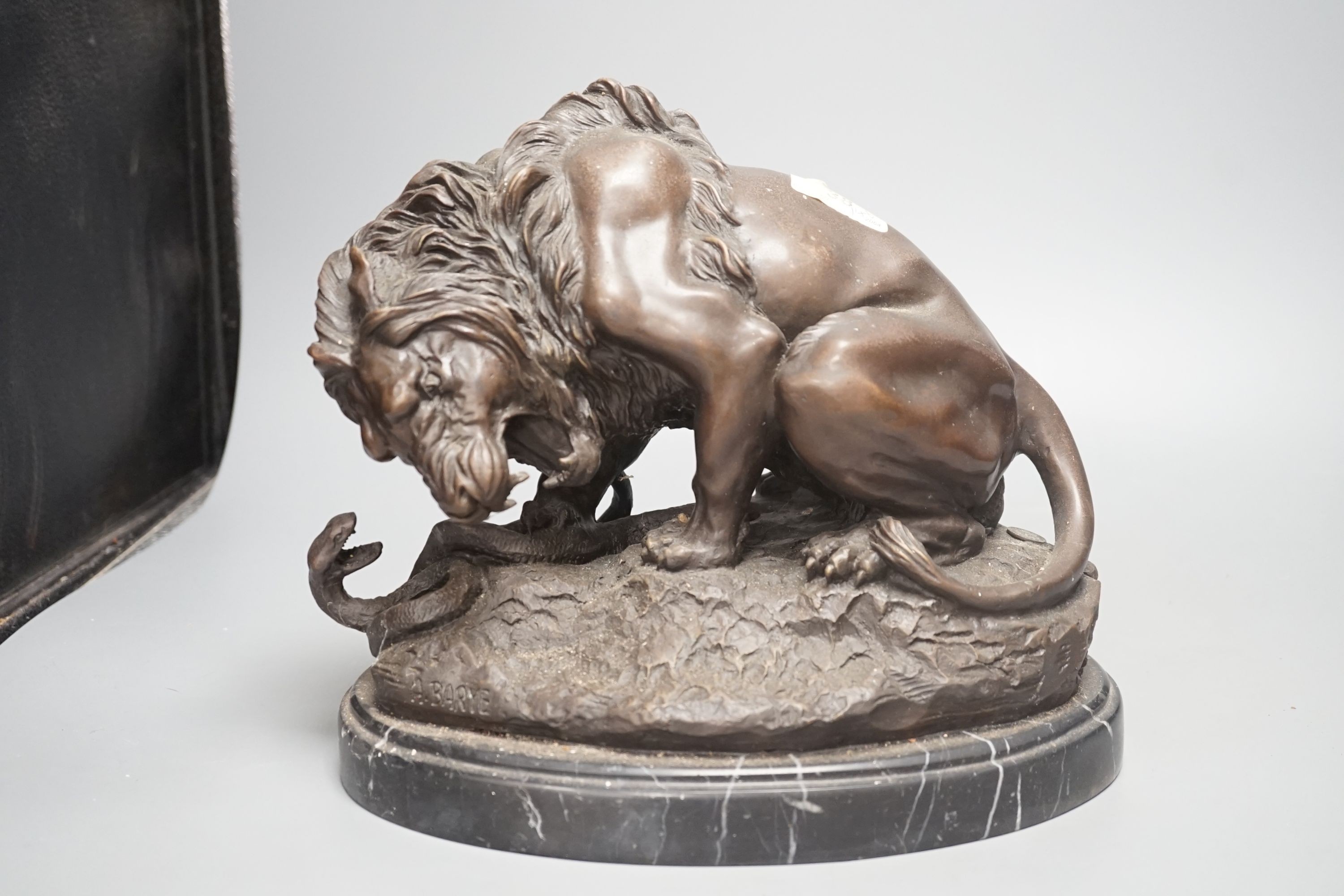 After Barye, a bronzed metal lion and serpent group, 25 cms high.